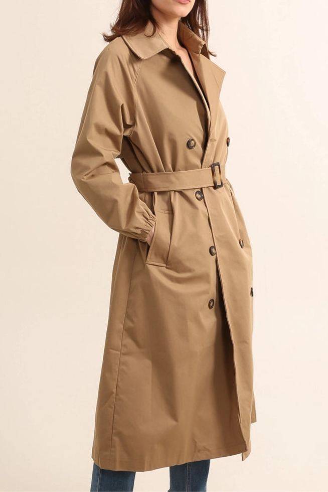 Woman wearing gale camel beige trench coat on a beige background - by penn and reid boutique leighton buzzard
